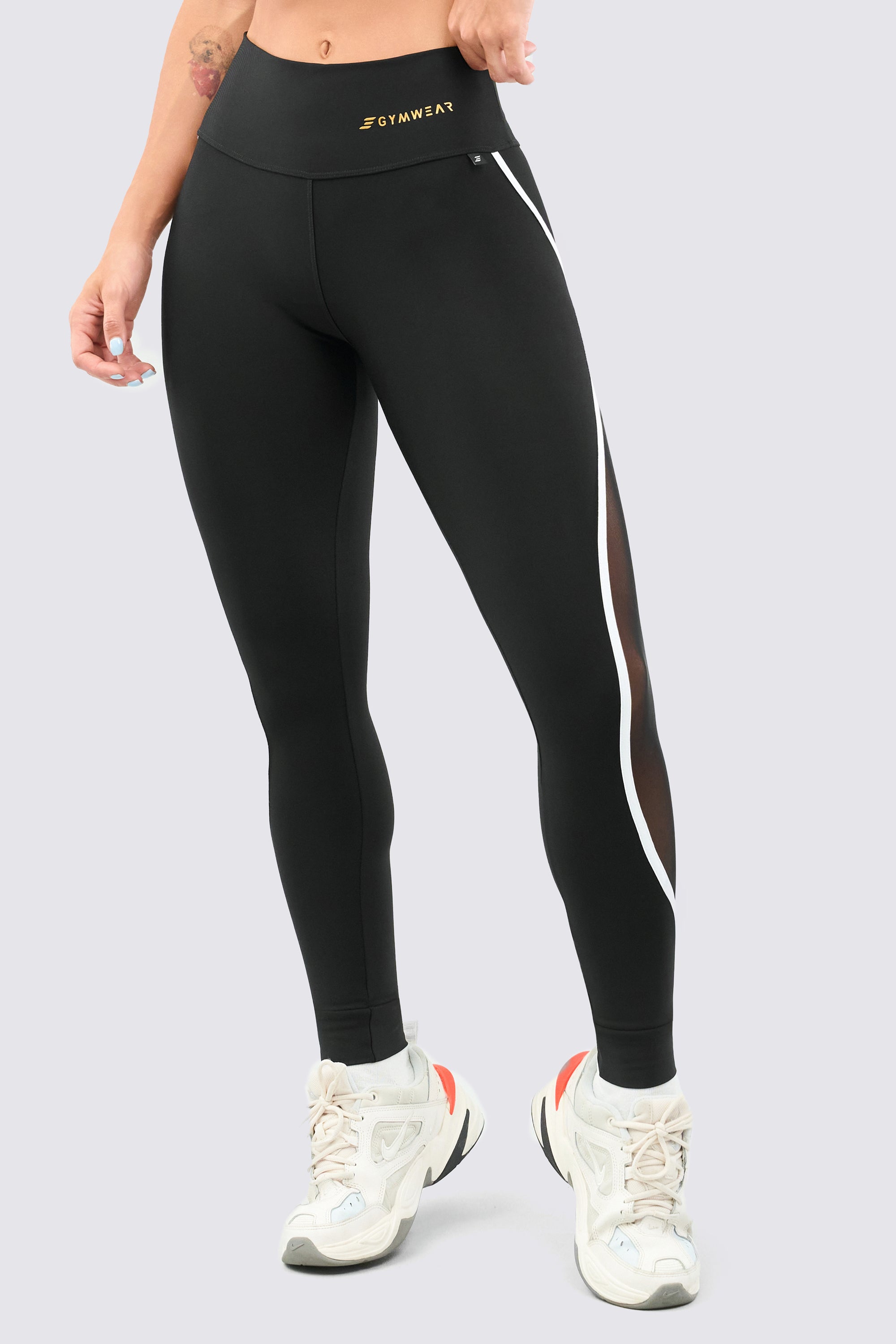 Black leggings with mesh panels, high rise and white stitching, soft and lightweight fabric.