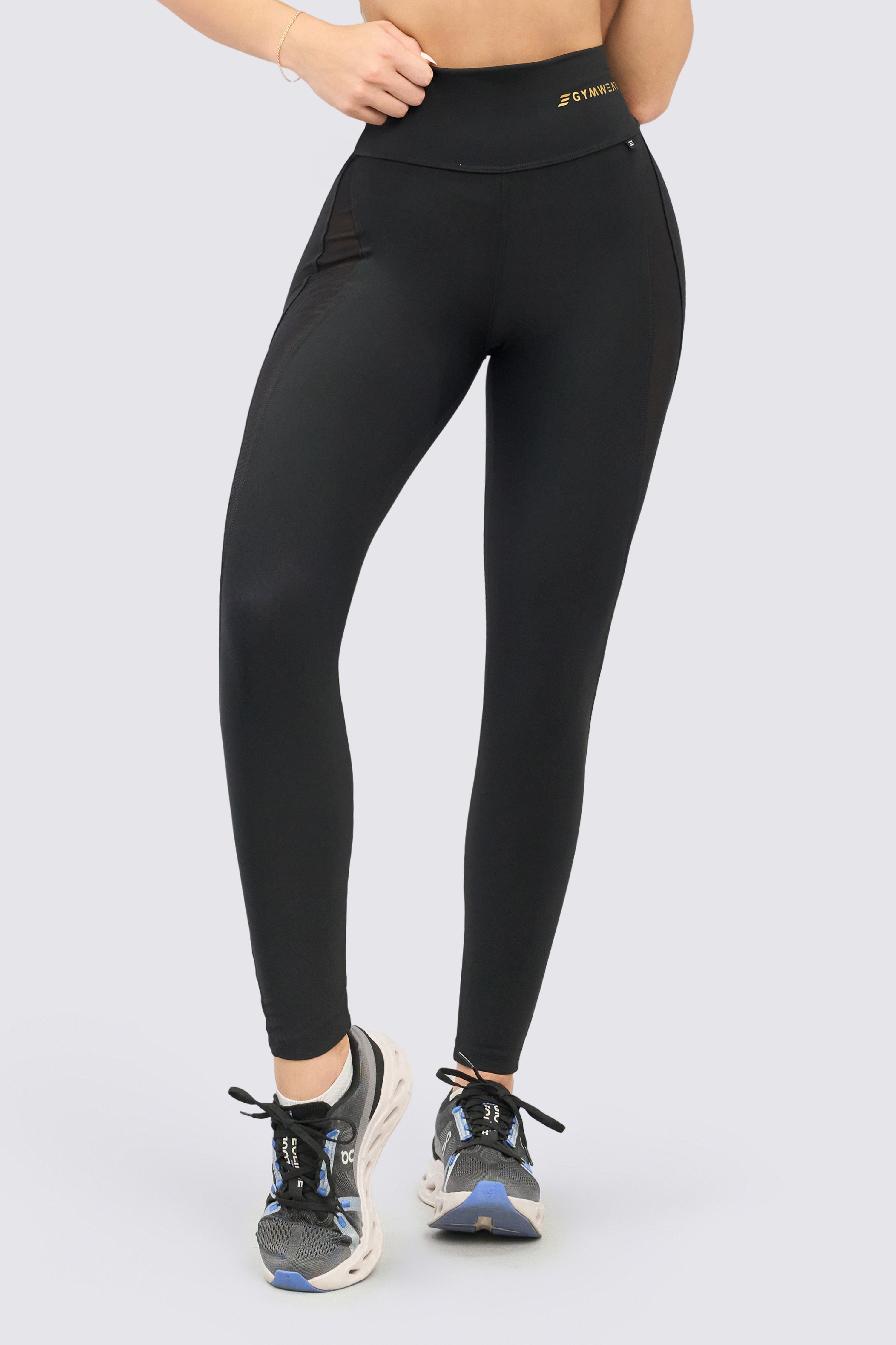 Black athletic leggings with a high waist and embedded mesh panels.