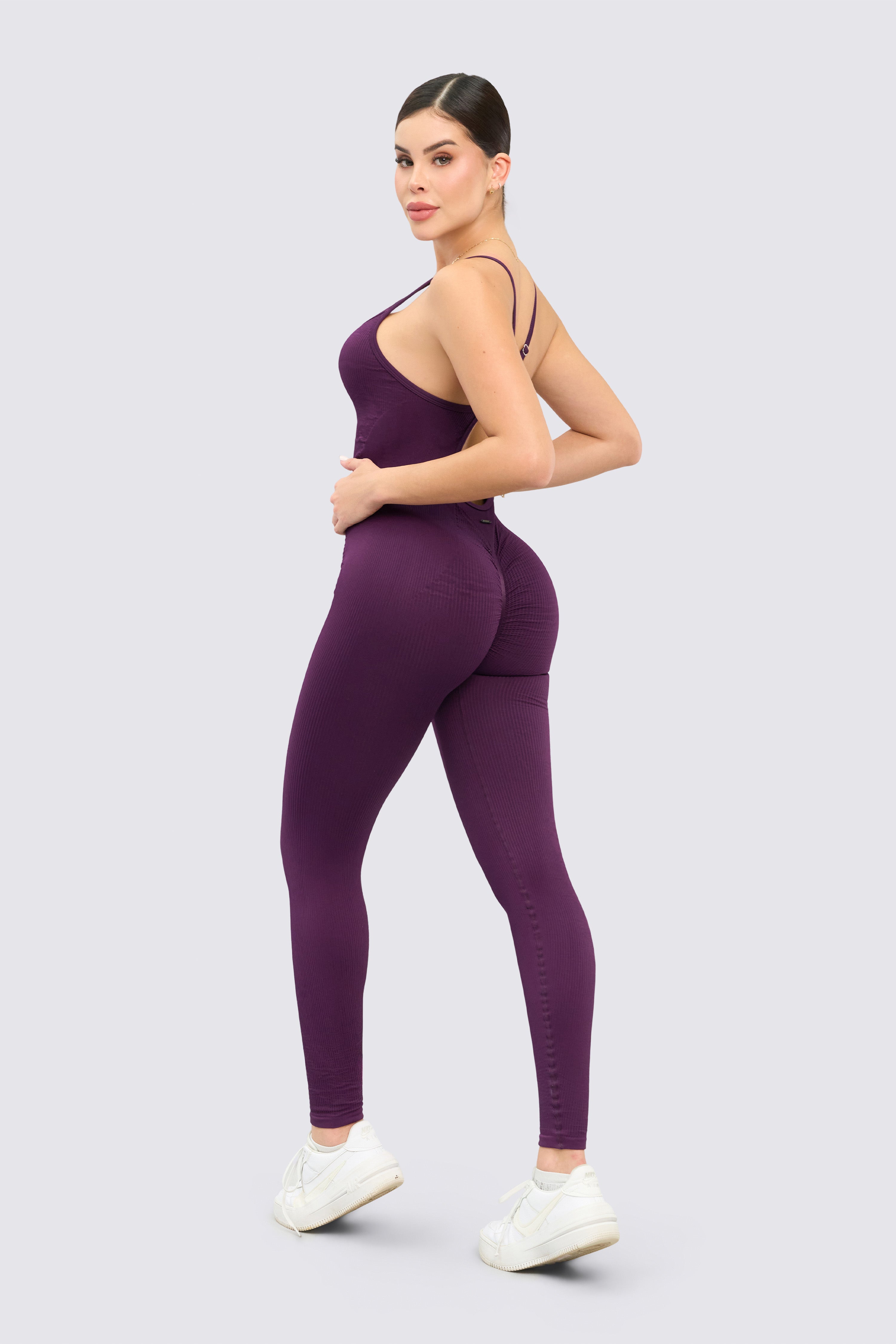 Seamless purple jumpsuit with back neckline, thin straps, and scrunch at the buttocks.