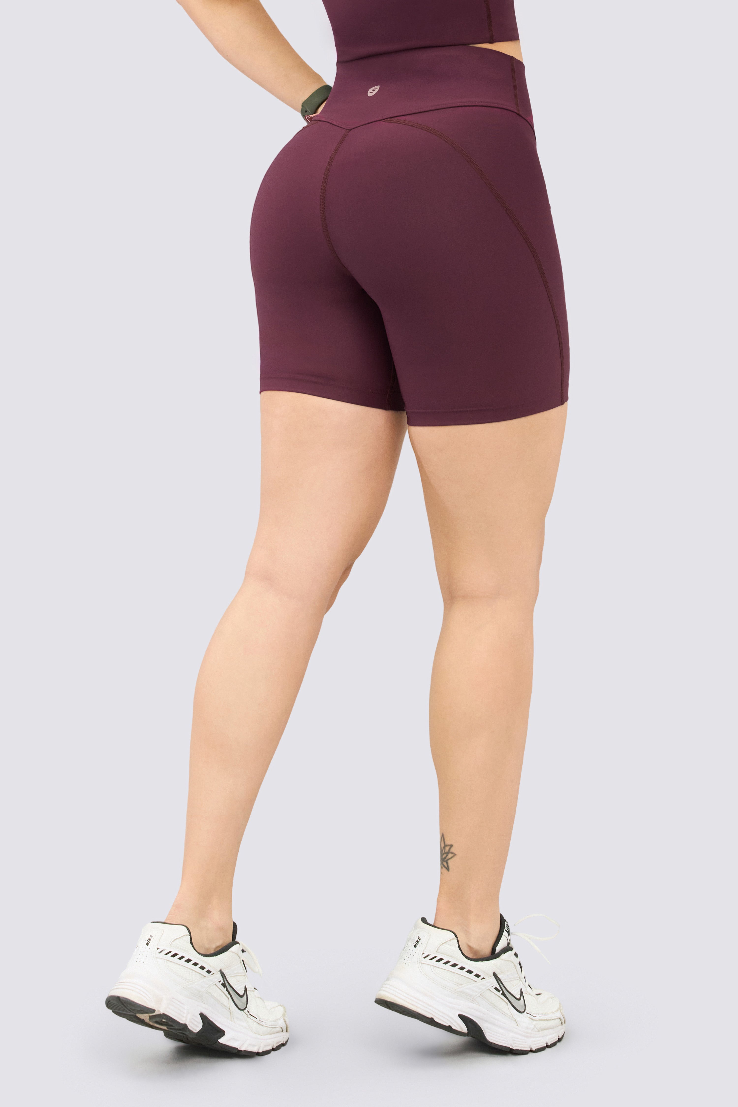 Sporty burgundy green biker pants with a high waistband and seams that slim the silhouette.