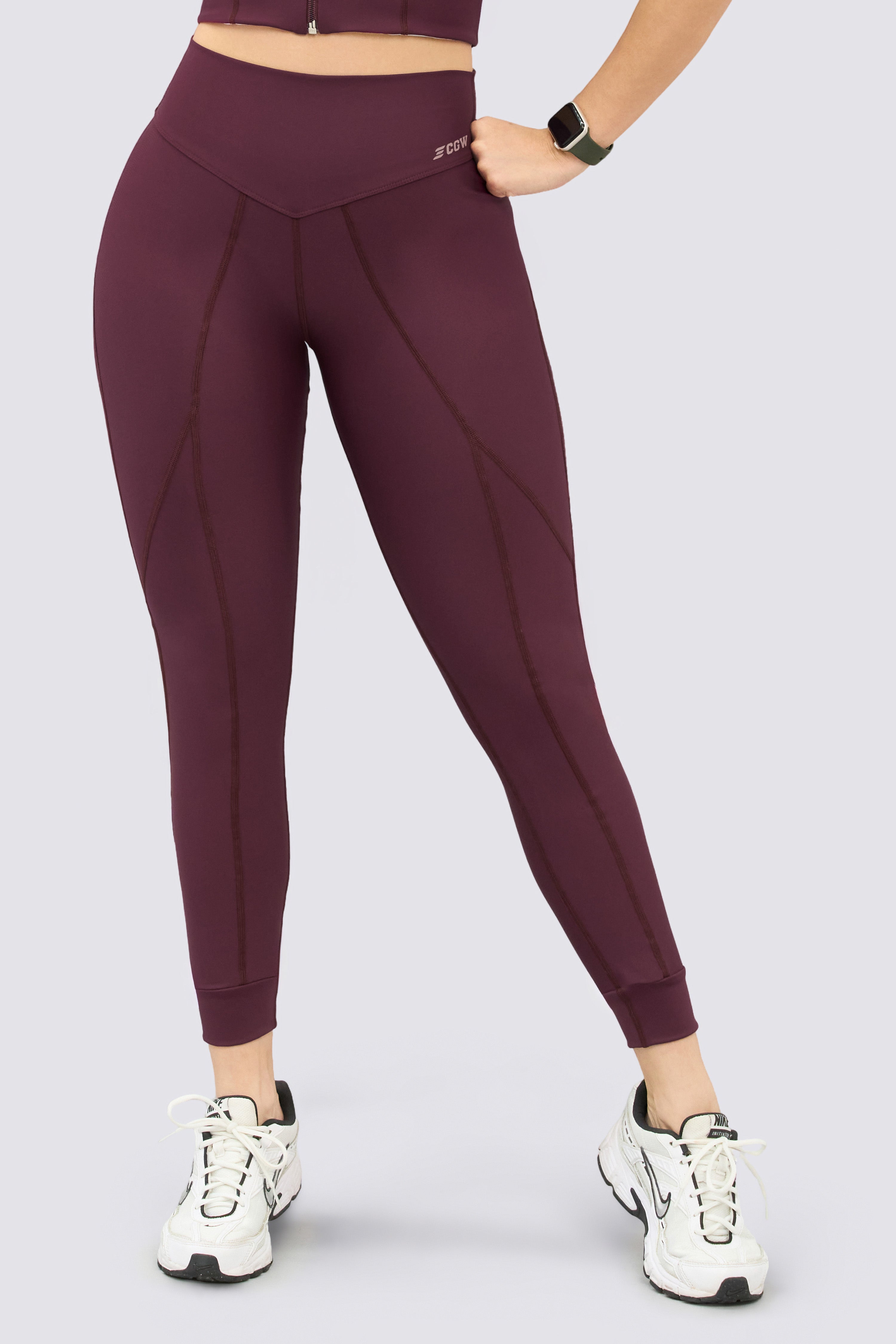Burgundy sports leggings with figure-flattering seams and a high waistband.