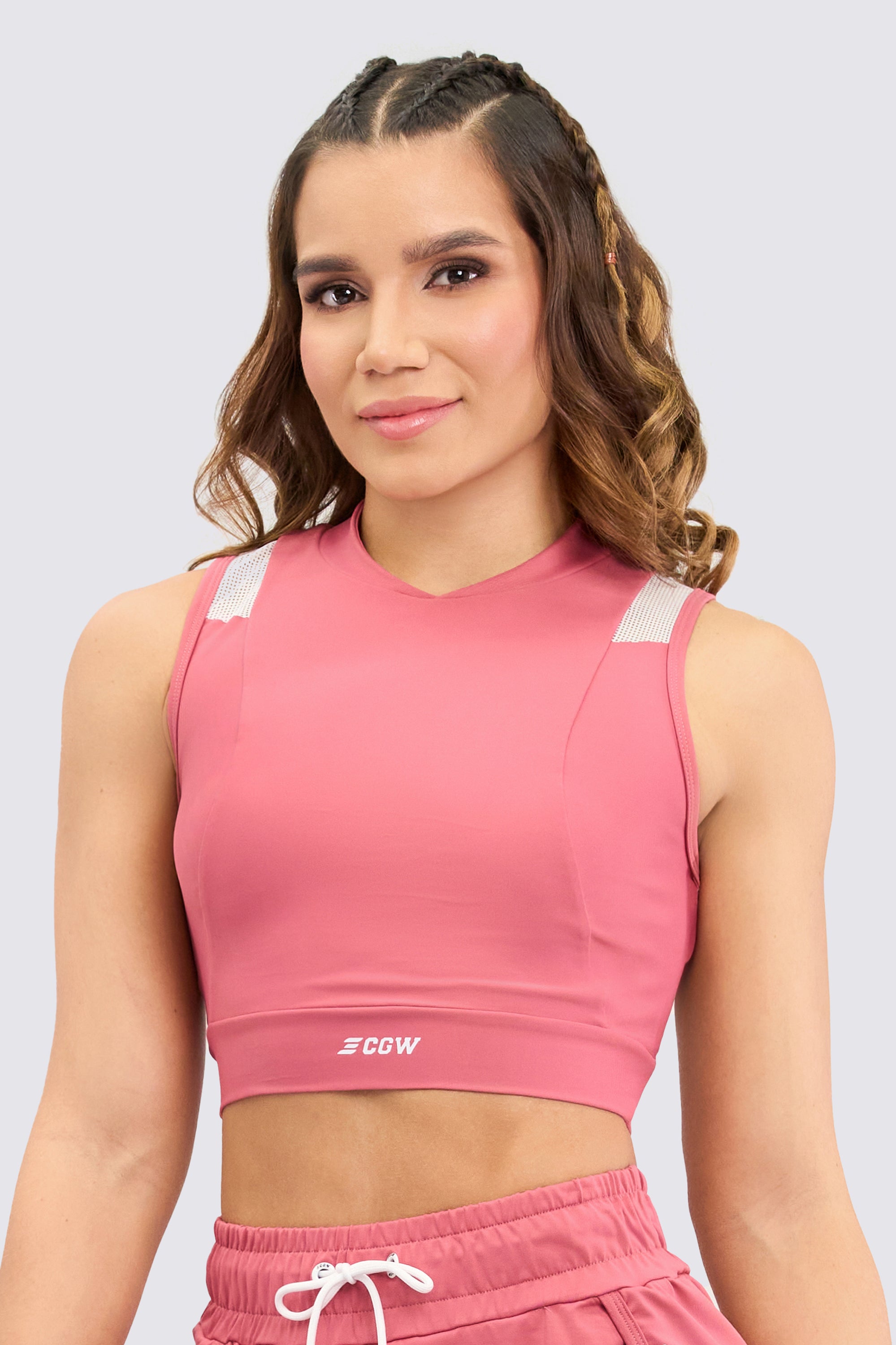 Pink sporty crop top, with mesh panels on the shoulders, soft and elastic texture design.