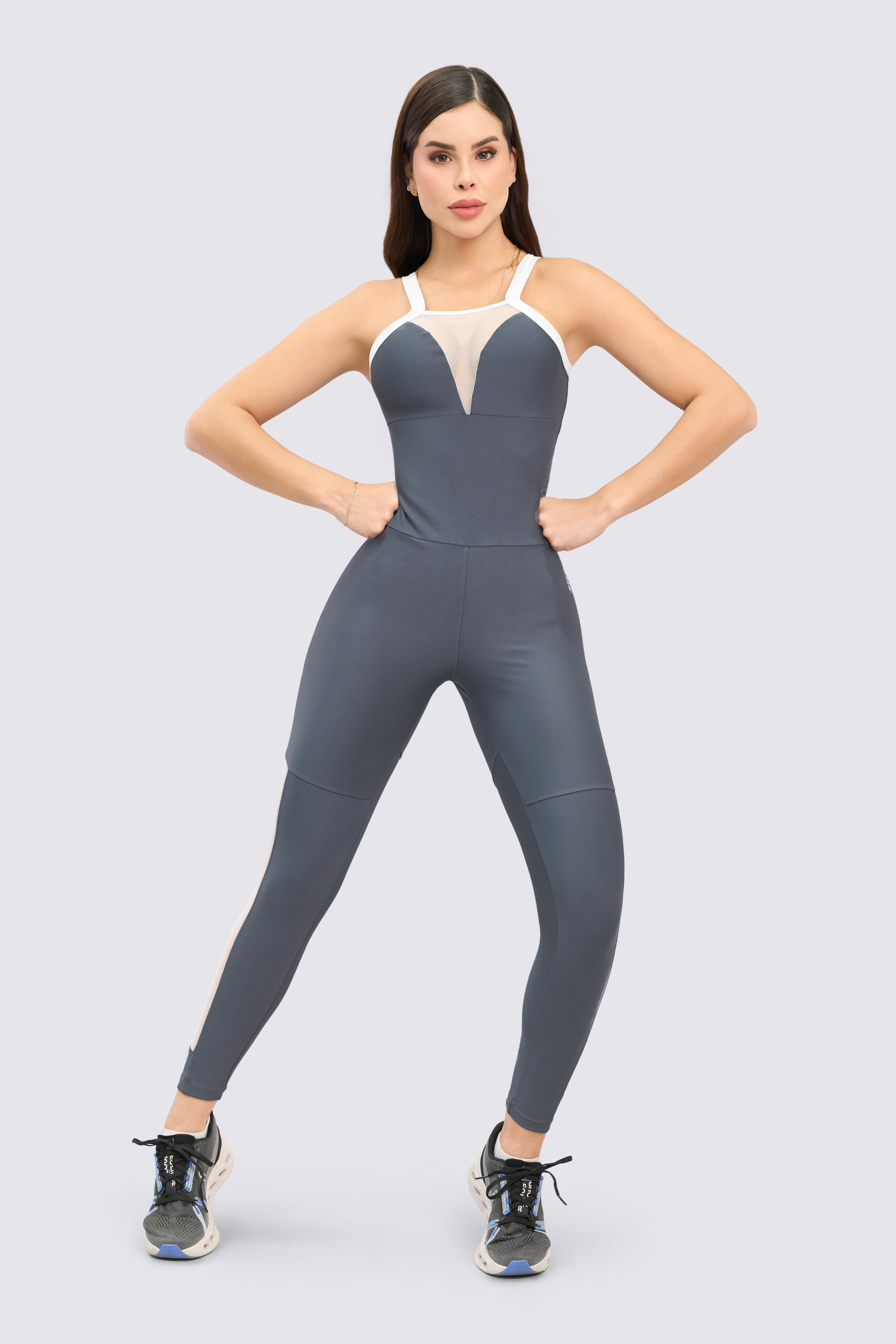 Gray sports jumpsuit with embedded mesh panels that aid ventilation during exercise.