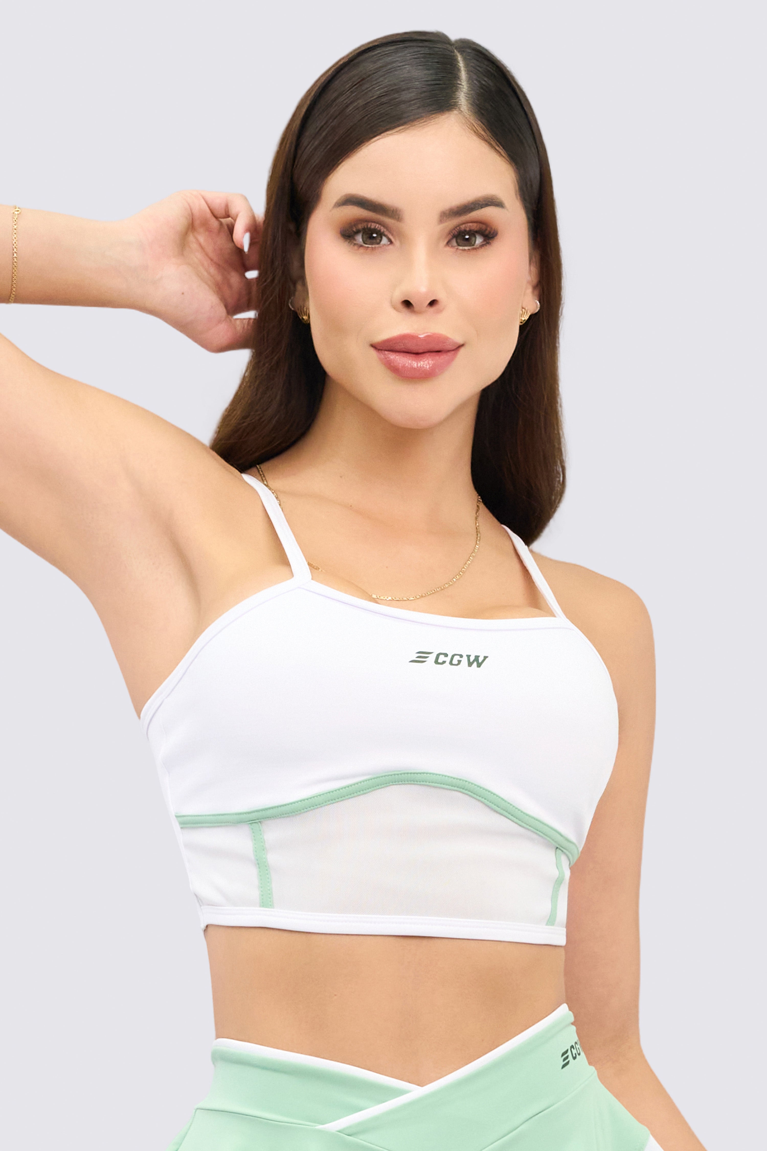 White sports top with green details, front mesh for greater ventilation, and thin straps. 