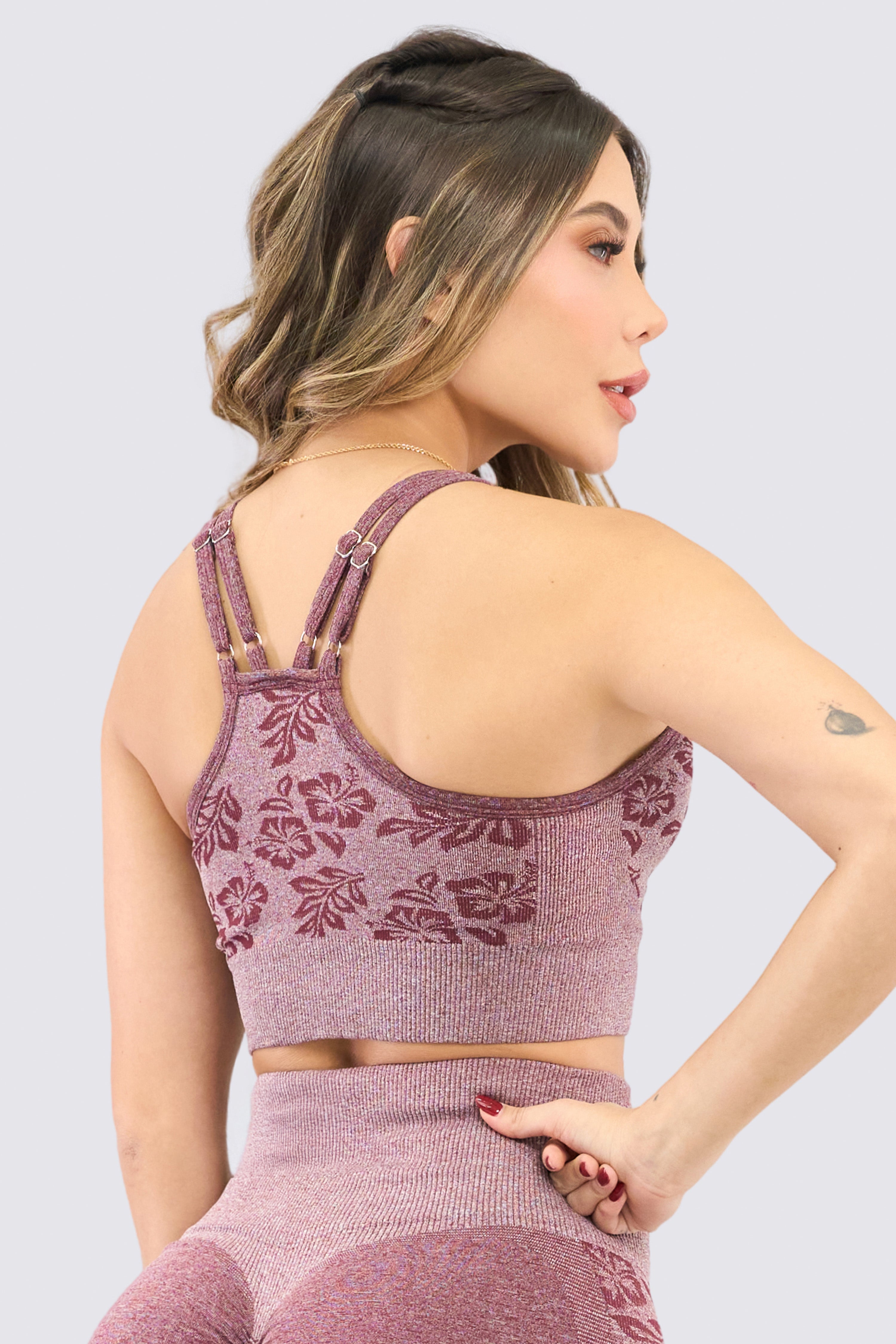 Dark cherry-colored sports top with floral pattern, adjustable straps, and removable cups.