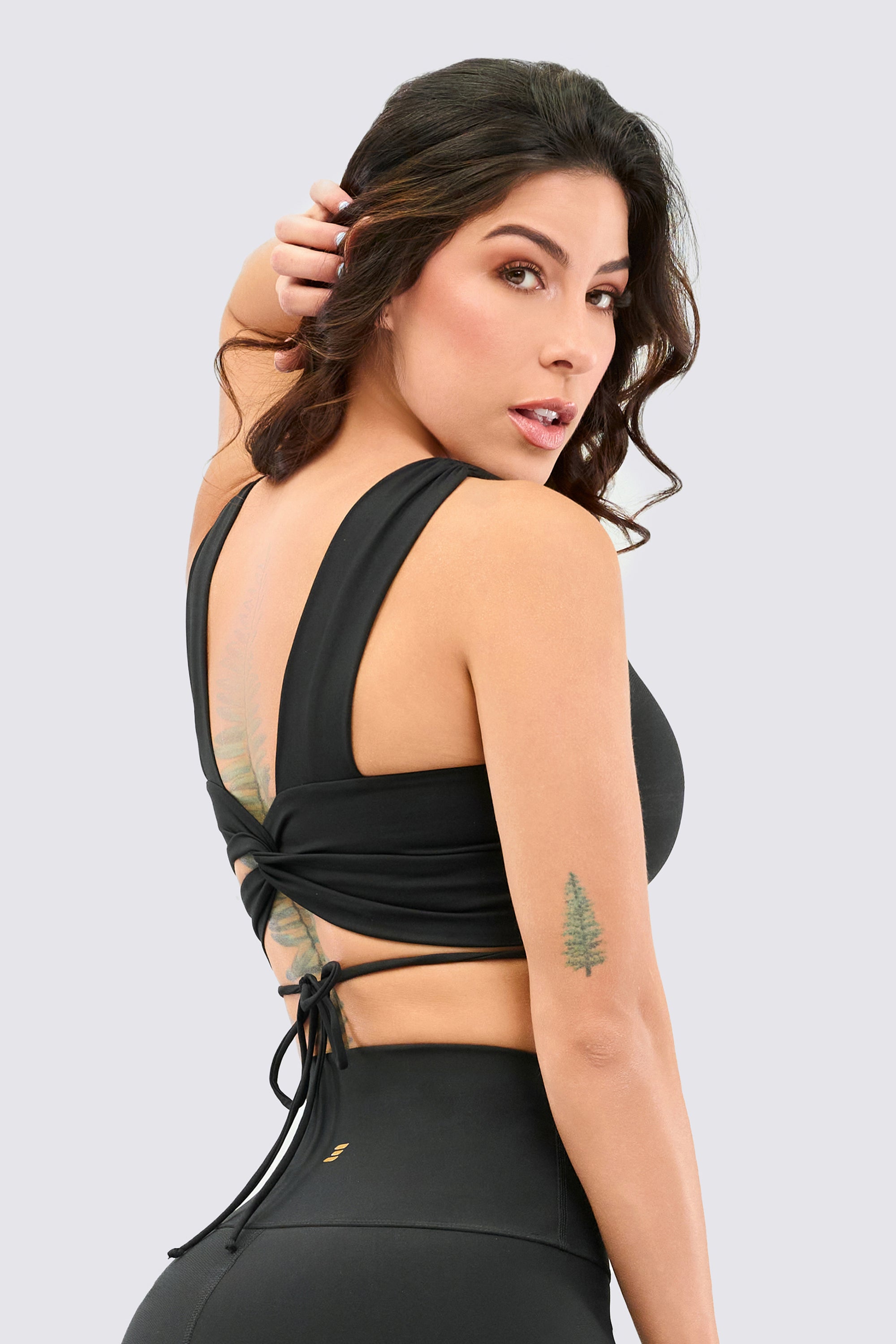 Black sport top, with strap adjustment that wraps around the waist.
